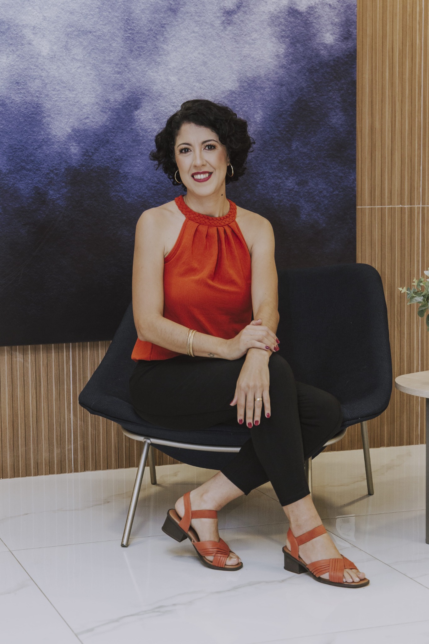 Adriana Crepaldi sentada em uma poltrona